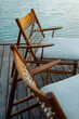 © Alexander Grabchilev/Stocksy - Wooden Lounge Chairs with Woven Backrests by the Water