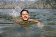 © VICTOR TORRES/Stocksy - Boy's joyful swim on summer day in scenic mountain lake.