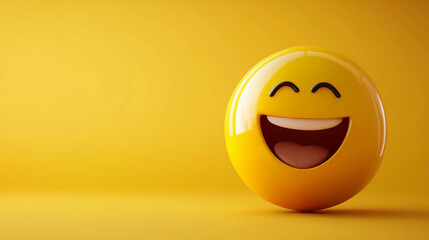 A laughing face emoji ball on a yellow background with copy space. Representing positive emotions like joy, happiness, or laughter.