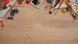 © Prathankarnpap - A wooden table with a variety of art supplies including paint brushes, watercolor and canvas