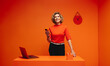 © Jacob Lund - Happy woman texting on cellphone in vibrant monochromatic orange office set, emphasizing creativity and modernity