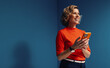 © Jacob Lund - Mature woman smiling while using smartphone in vibrant, colorblocked setting with orange and blue