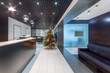 © alhim - Christmas tree in the interior of the office lobby. Reception desk and sofa for comfortable waiting.