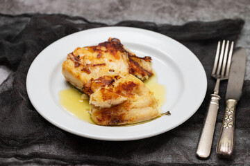 Sticker - fried cod fish with olive oil on white dish