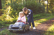 © Irina Schmidt - Two happy children playing with big old toy car in autumn forest, outdoors. Kid boy pushing and driving car with little toddler girl, cute sister inside. Laughing and smiling kids. Lovely family