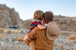 © Irina Schmidt - Father and son traveling through West of USA in Grand Canyon. Happy little child and young man. Dad holding boy on arms., looking on mountains