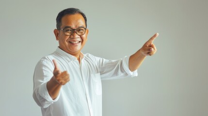 A joyful man in glasses and a white shirt enthusiastically gestures with both hands, exuding positivity and friendly confidence in a warm setting.