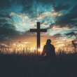© Ilja - Silhouette of Man Praying at Sunset with Cross, Faith, Hope, and Christianity Concept.
