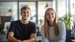 © PhotoHunter - two joyful young interns sitting in a bright office, smiling confidently, warm light on their faces, casual but professional setting, friendly and inviting workspace