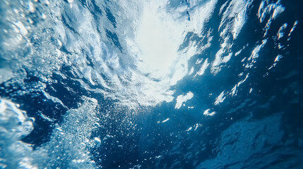 Wall Mural - blue ocean surface seen from underwater: a view from underwater looking up at the blue ocean surface