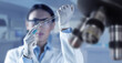 © Paulista - Professional lab technician dripping blue liquid sample in a test tube for microbiological research, medical study or trial.