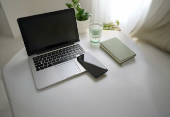 Poster - A laptop, a smartphone, and a notebook lie on a white desk.