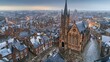 Aerial view of a historic church surrounded by quaint rooftops at dusk.