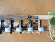 © scentrio - Aerial view of the dam's floodgates with rapid flow of water in the rainy season. Dam water release, dam overcapacity after heavy rain.