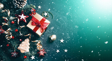 Poster - Christmas dark blue and green background with golden gift box and decorated fir branches, flat lay.