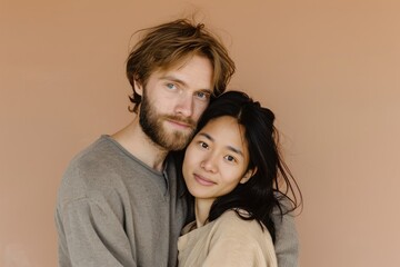 Portrait of a happy young couple embracing each other on a beige background