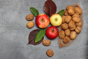 Wall Mural - Red apples and autumn leaves on gray background. Top view, copy space