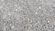 © Maule - A close-up of a rough, textured concrete surface with visible small stones. Perfect for industrial, construction, and abstract design projects