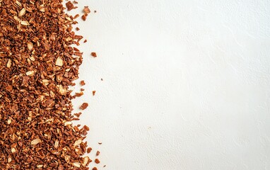 Dried brown granola scattered on a serene white surface, showcasing a healthy breakfast option