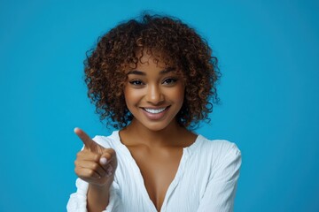 Poster - Portrait of a woman with curly hair pointing at the camera, isolated on a white background