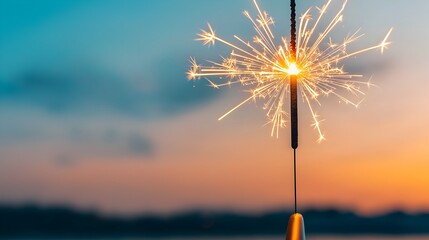Poster - Glowing sparkler against the fading light of sunset symbolizing the joy freedom and festive atmosphere of an outdoor or party  The flickering flame and sparks create a radiant