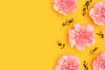 Wall Mural - pink carnation flowers and eucalyptus branches on a yellow background. frame with place for your des