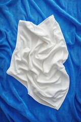 Wall Mural - A simple still life image featuring a white towel placed on top of a blue blanket