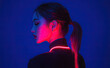 © Kien - a young woman with neon pink light on her back, against a solid dark blue background