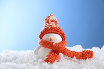 Wall Mural - Cute decorative snowman on artificial snow against light blue background