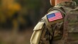 © zhou yan - Close-up view of a U.S. military uniform featuring an American flag patch on the arm, set against a blurred background. This composition provides ample space for text, emphasizing themes of patriotism