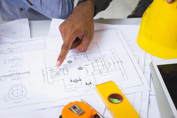 Architects point at blueprint. Architects Brainstorming idea to design consulting and analyzing on blueprint and model building in working construction site.