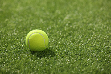 Canvas Print - Tennis ball on green artificial grass, space for text