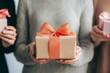 © KENZOGROW - Gift box held by person, surrounded by others, cozy setting.