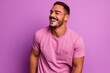 © Igor - Portrait of a happy young man laughing while standing against purple background