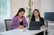 © amnaj - Two businesswomen are having a productive meeting in the office, discussing a new project