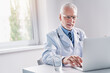 © InsideCreativeHouse - Doctor online. Senior medic talking to client on laptop computer from his office