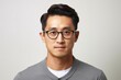 © Igor - Portrait of young asian man with eyeglasses over grey background