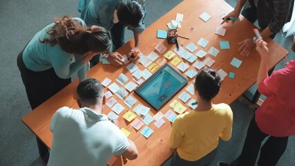 Top view of skilled programmer brainstorming idea about mobile phone interface while develop app development by using wireframe prototype. Web designer planning at table with sticky notes. Symposium.