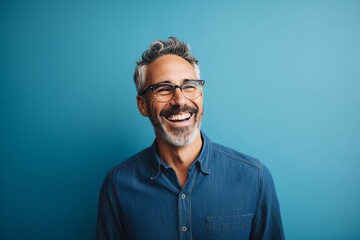 portrait of a happy mature man with eyeglasses against blue background