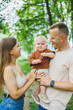 © DSMT - Mom, dad and little son on a walk in the park. Concept of parent time with child. Happy family couple with child in nature.