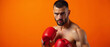 © EA Studio - Athletic male boxer posing fiercely against a vibrant orange background