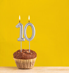 Poster - Number 10 birthday candle - Chocolate cupcake on a yellow background.