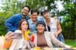 © CandyRetriever  - Group of Happy Asian millennial people friends enjoy and fun celebration reunion meeting using mobile phone taking picture together at dinner party in the garden at restaurant on holiday vacation.