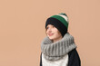 © Pixel-Shot - Cute little boy in warm winter clothes on beige background