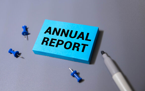 Business Annual Report text on a black folder near a cup of coffee.