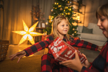 Sisters enjoy christmas gift in cozy living room setting