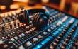 © Nattapat - An intricate closeup of a mixing console and headphones in a podcasting studio, representing the technical side of professional audio production