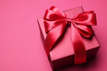 Sticker - Gift box with bow on pink background. Space for text