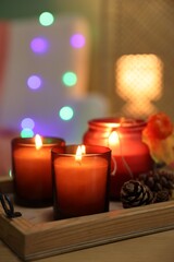 Canvas Print - Burning candles and autumn decor on wooden table indoors, closeup