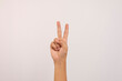 © Luqman Aditiamala - Close up of Caucasian male hand showing number two gesture isolated on white studio background. Hand number concept for people with disabilities.